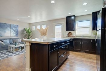 A kitchen with a large center island and black cabinets at copper pines, bozeman, mt, 59718